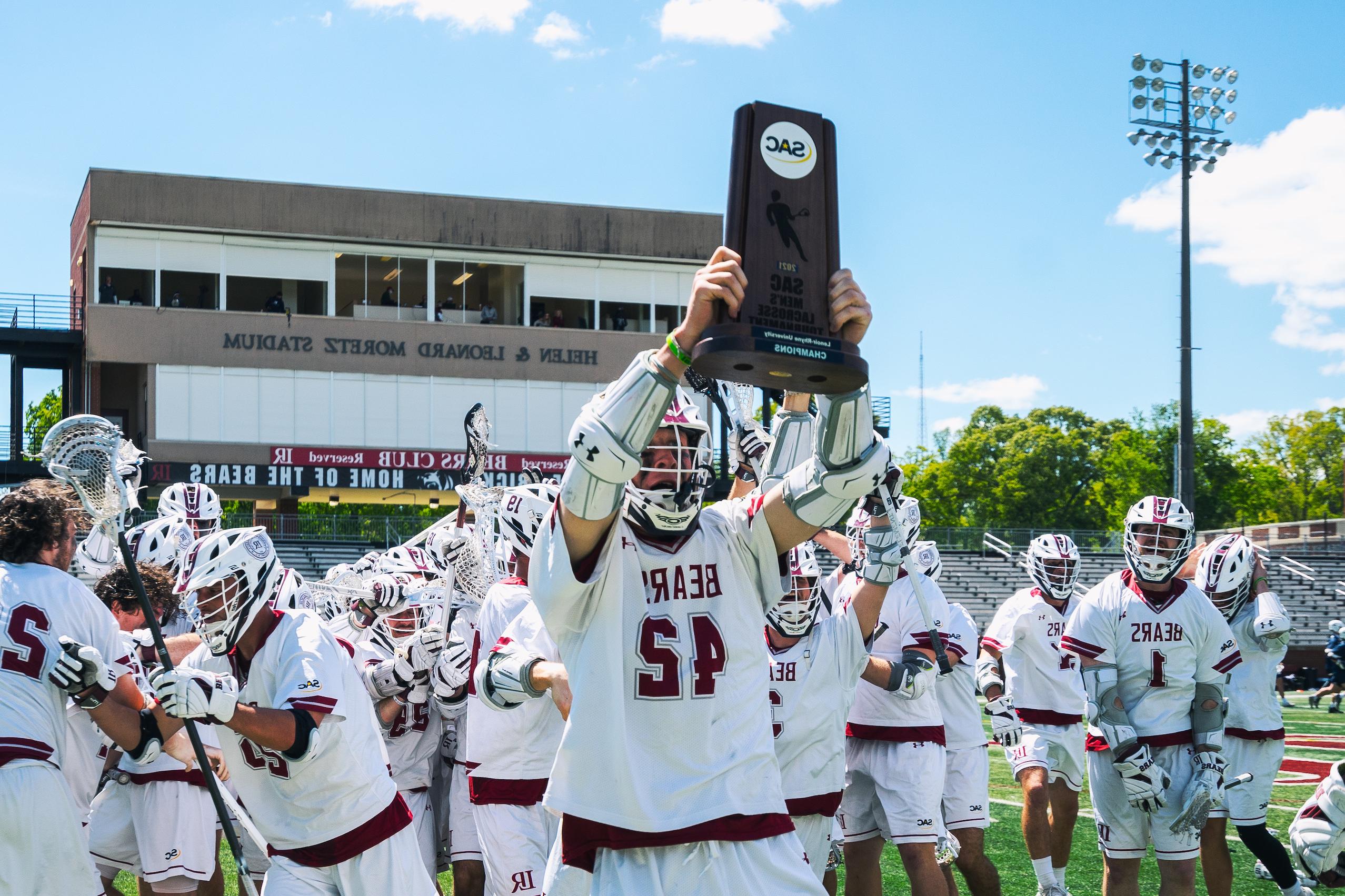 All-American and all-time scoring record holder Eric Dickinson ’21 holds up the South Atlantic Conference championship trophy.