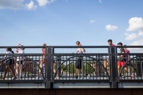 Students walk across a bridge on a sunny day