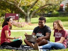 LR students laughing and talking sitting on the lawn