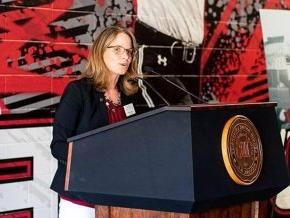 Athletic Director Kim Pate speaks at a podium unveiling the center