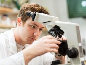 Chase White works with a microscope in a science lab