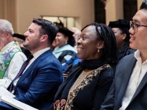 Lillian Okoronkwo sits in a church pew amongst other congregation members. 